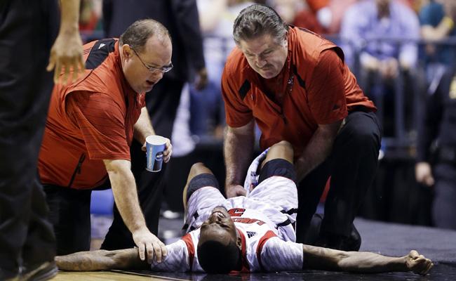 Trainers check on Louisville guard Kevin Ware (5) after Ware injured his lower right leg during the first half of the Midwest Regional final against Duke in the NCAA college basketball tournament, Sunday, March 31, 2013, in Indianapolis. Ware left the court on a stretcher. (AP Photo/Michael Conroy)